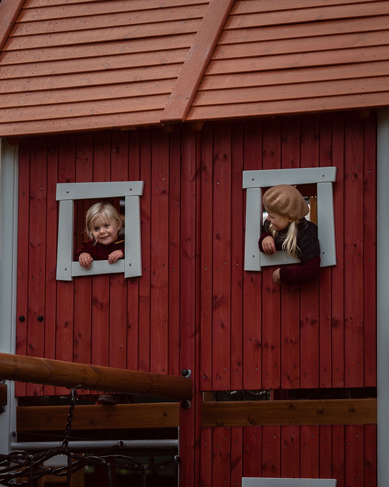 Two little girls looking out from a UniPlay unit.